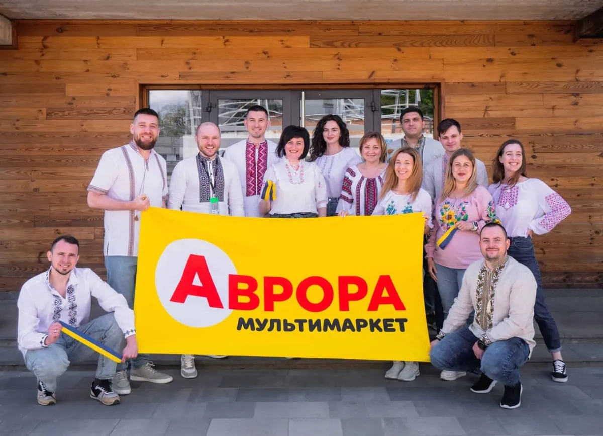 Aurora team wearing traditional Ukrainian embroidered shirts with the company flag
